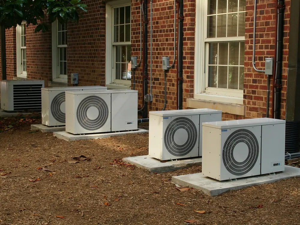 Ductless mini-split heat pump head mounted on a living-room wall