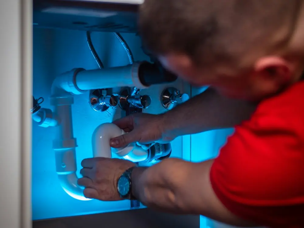 Plumber working under a kitchen sink